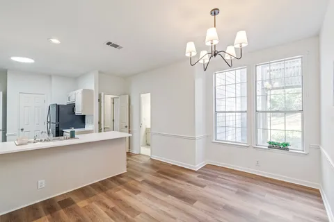 a view of a hallway with wooden floor and closet