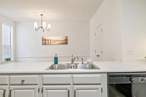 a bathroom with a granite countertop sink mirror and window