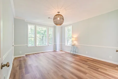 a view of a hallway with wooden floor and a cabinet