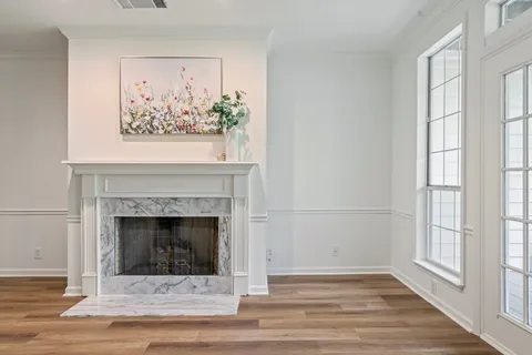 a view of empty room with wooden floor and fireplace