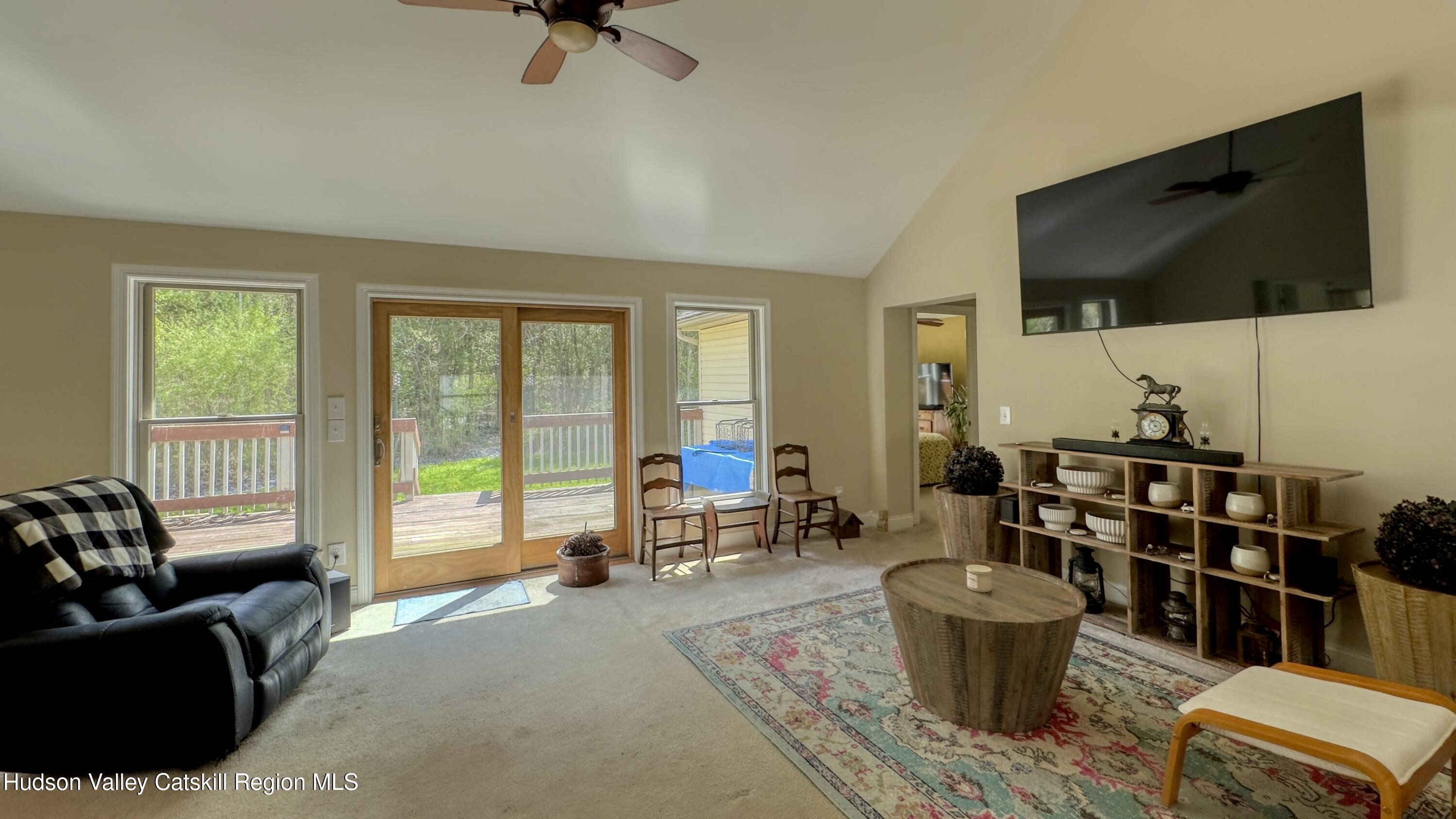 996 Sleepy Hollow Road Athens, NY 12015 - Photo 6 of 32 a living room with furniture a flat screen tv and floor to ceiling window