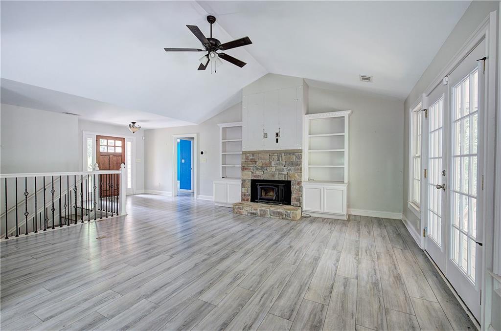 561 Holland Road Dallas, GA 30157 - Photo 6 of 48 an empty room with wooden floor fireplace and windows
