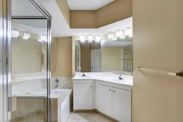 a bathroom with a double vanity sink mirror and shower