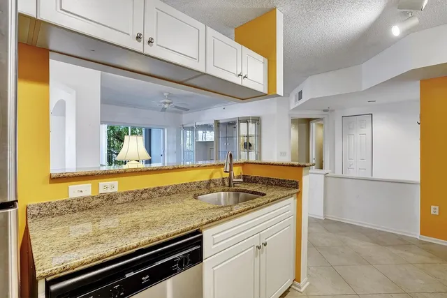 a kitchen with stainless steel appliances granite countertop a sink and a refrigerator