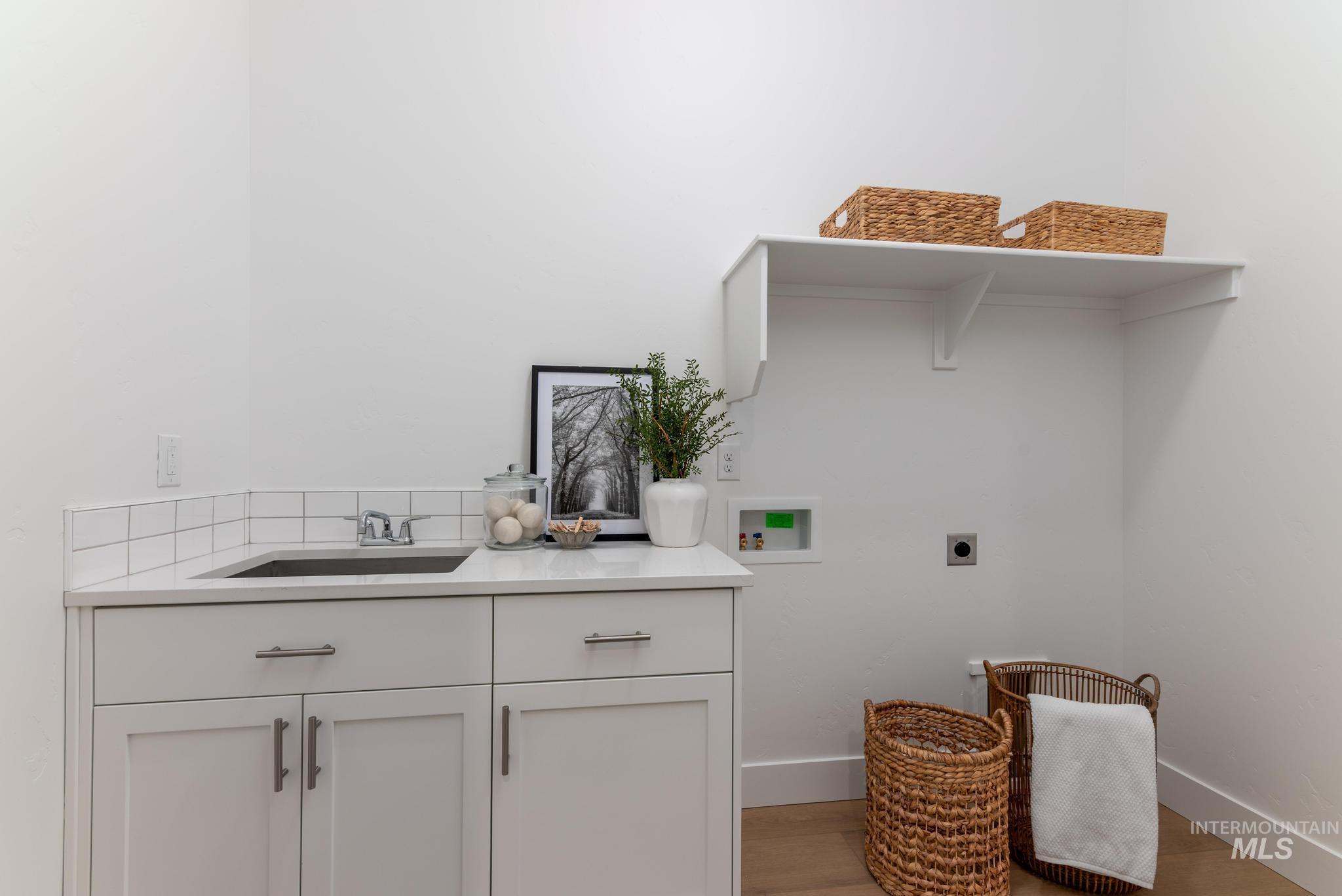 3612 North Pindall Way Star, ID 83669 - Photo 9 of 12 Laundry area featuring hookup for a washing machine, electric dryer hookup, light wood-style flooring, and cabinet space