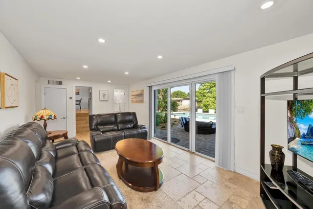 a living room with furniture a rug and a floor to ceiling window