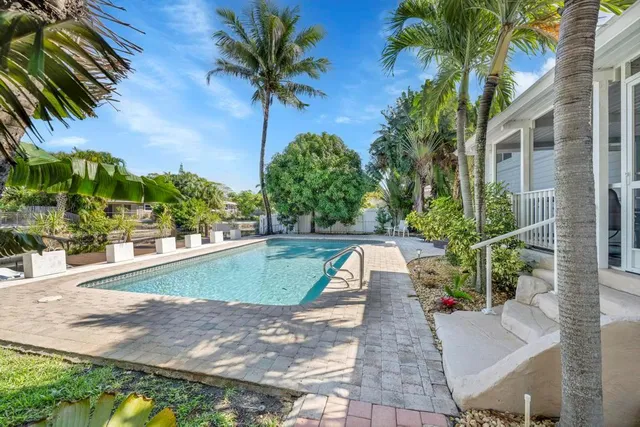 a swimming pool with outdoor seating and plants