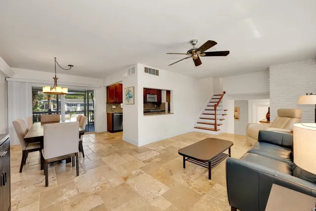 a living room with furniture a ceiling fan and a rug