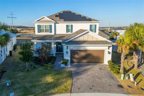 a front view of a house with a yard and potted plants