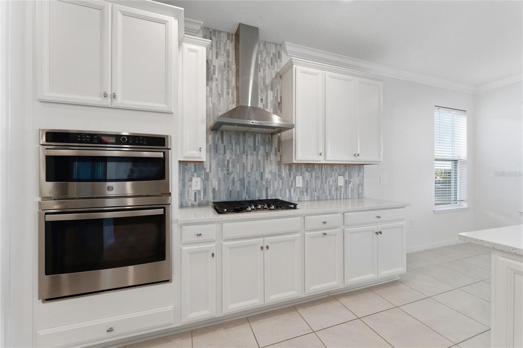 2834 High Pointe Circle Clermont, FL 34711 - Photo 6 of 39 a kitchen with white cabinets and appliances