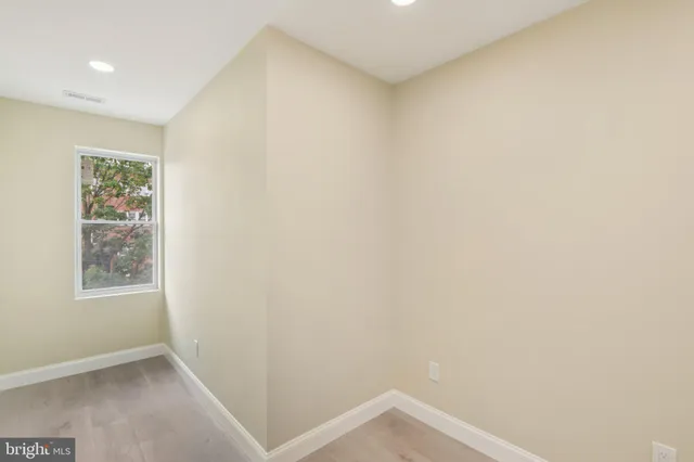 an empty room with wooden floor and a window