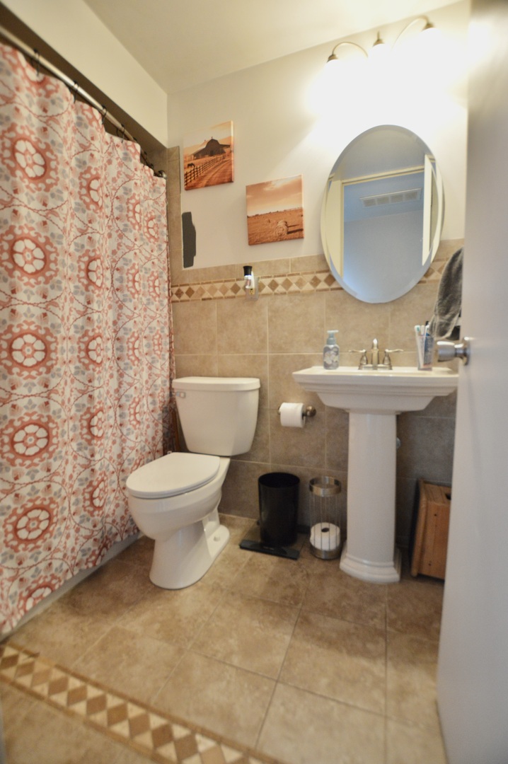 3206 Hunter Path McHenry, IL 60050 - Photo 11 of 13 a spacious bathroom with a toilet sink and mirror