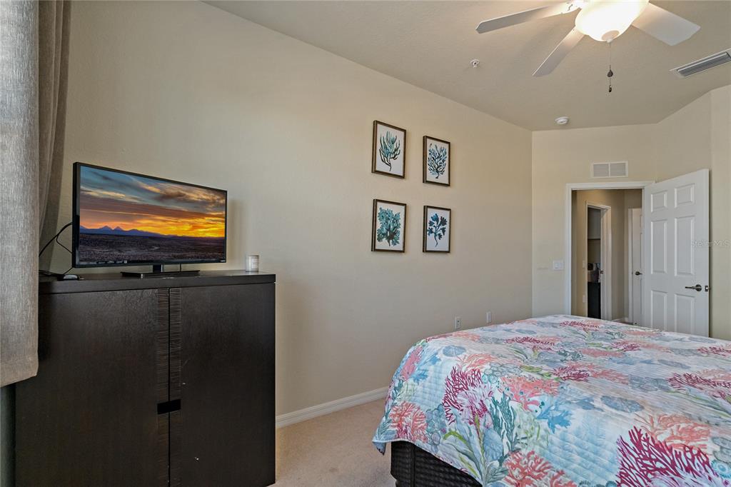 7015 Grand Estuary Trail, Unit 103 Bradenton, FL 34212 - Photo 22 of 62 a bedroom with a bed and a flat screen tv