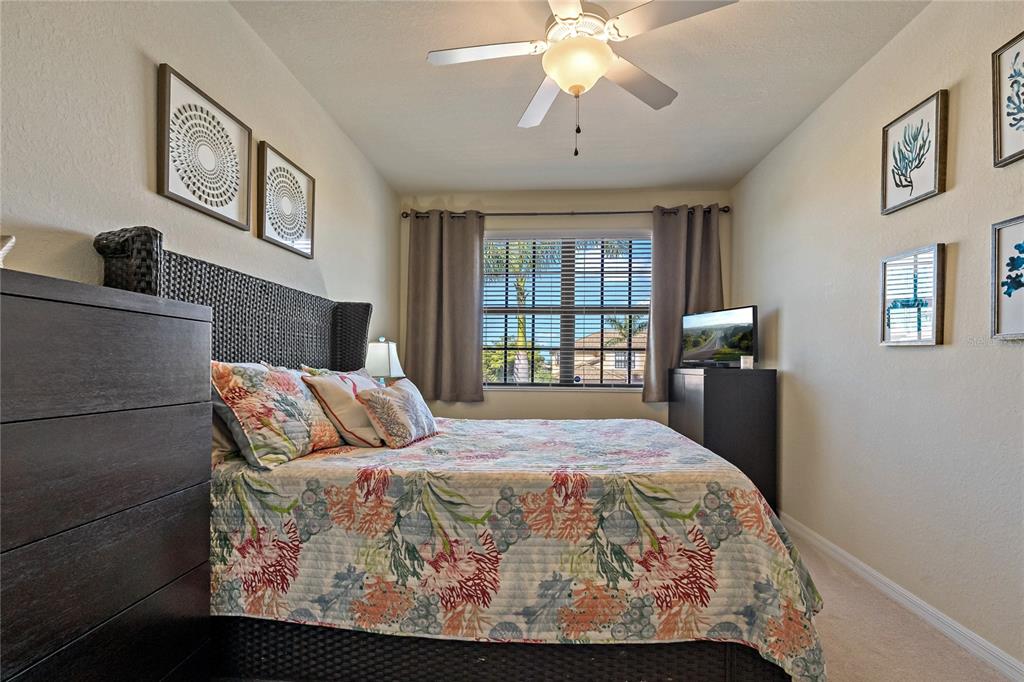 7015 Grand Estuary Trail, Unit 103 Bradenton, FL 34212 - Photo 24 of 62 a bedroom with a large bed and a chandelier