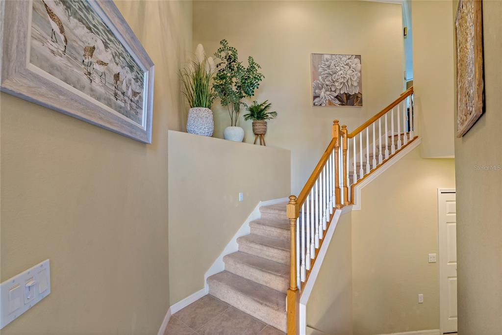 7015 Grand Estuary Trail, Unit 103 Bradenton, FL 34212 - Photo 42 of 62 a view of staircase with lots of frames on wall and a potted plant