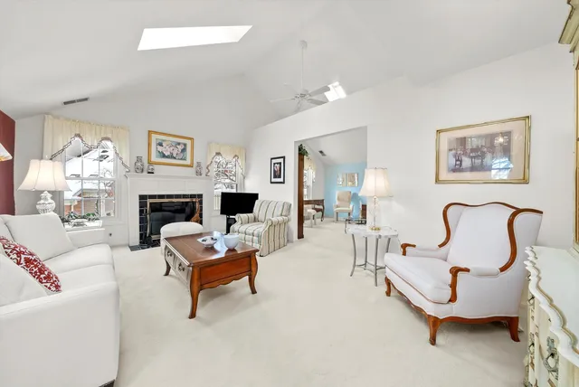 a living room with furniture a large window and a fireplace
