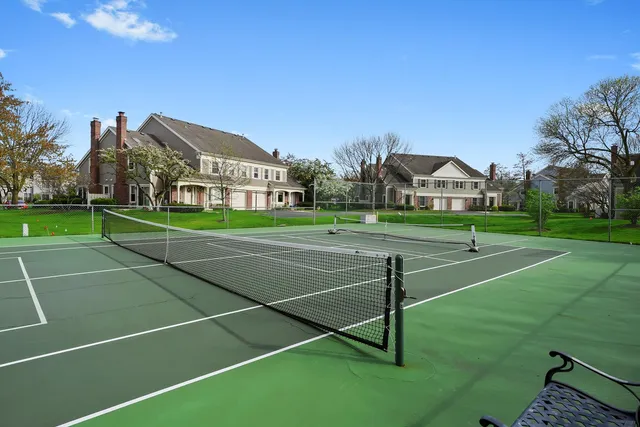 a view of a tennis ground with large trees