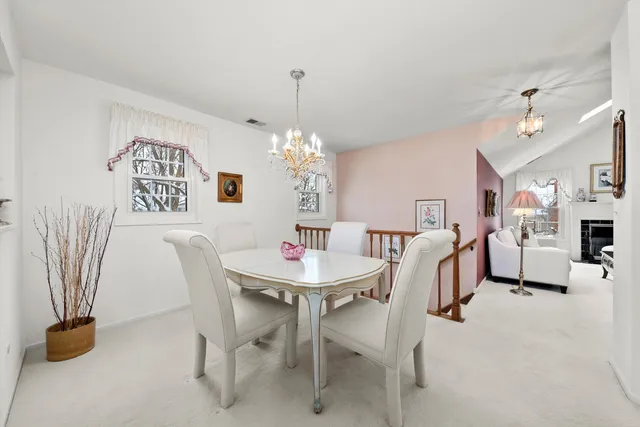 a view of a dining room with furniture and a chandelier