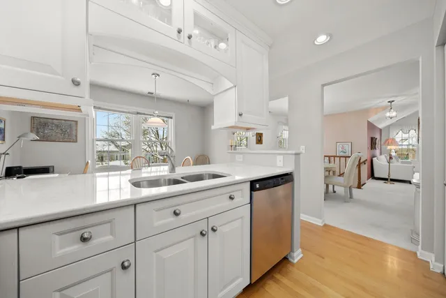 a kitchen with white cabinets and sink