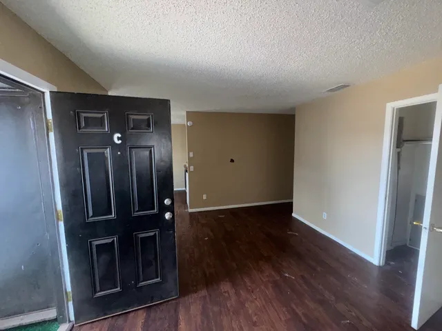 an empty room with wooden floor and cabinet