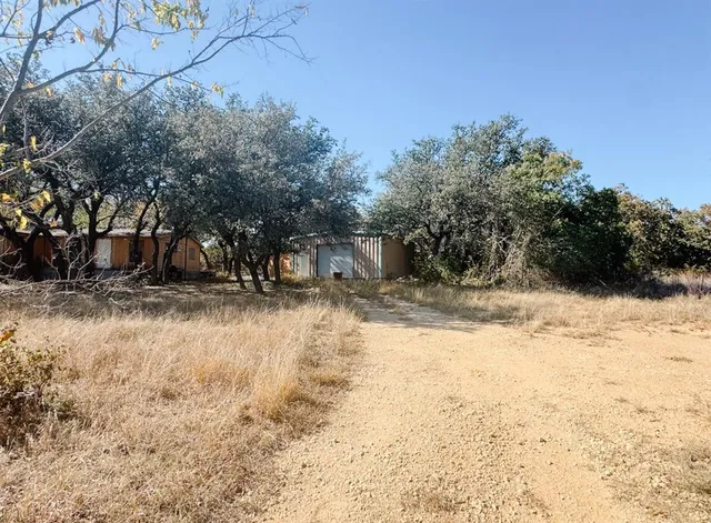 a view of a yard covered with snow in front of house