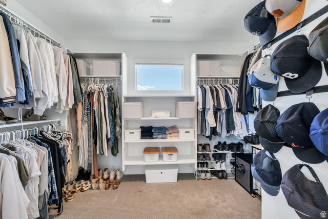 646 South Meade Street Mapleton, UT 84664 - Photo 26 of 46 Carpeted walk-in closet featuring extensive built-in shelving, multiple hanging rods, and a high horizontal window providing natural light
