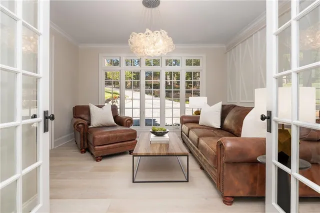 a view of a patio with couches chairs potted plants and wooden floor