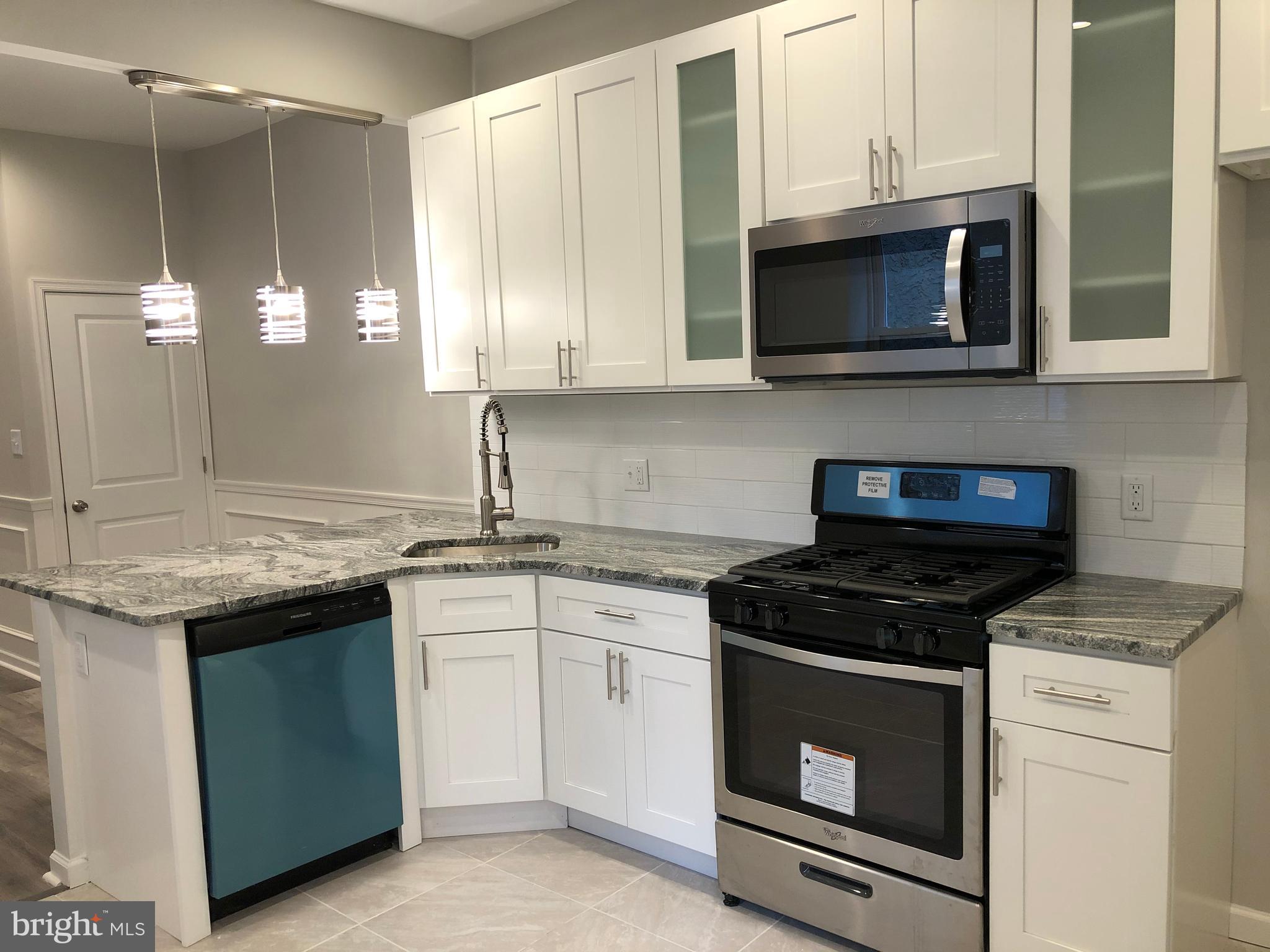 a kitchen with cabinets appliances and a sink