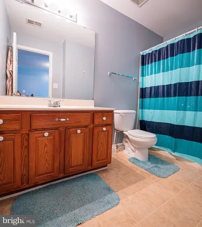 a spacious bathroom with a sink a toilet a mirror and shower