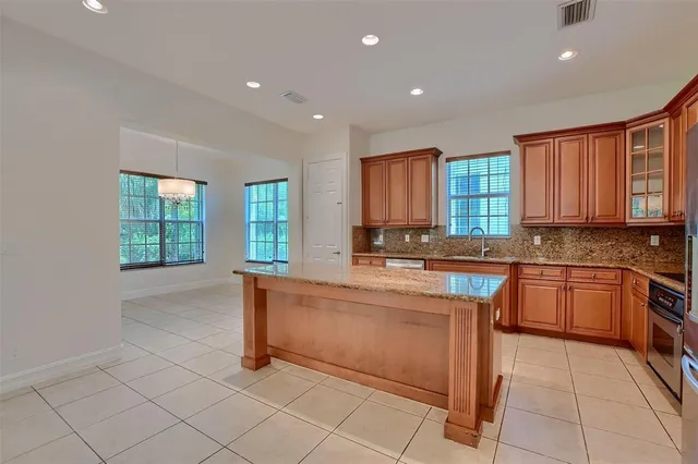 a kitchen with stainless steel appliances granite countertop a stove top oven a sink a counter space and cabinets