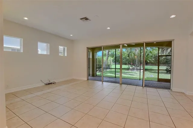 a view of an empty room with a stove and a large window