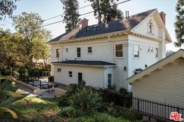 a view of a patio with couches and a table and chairs with wooden floor and fence
