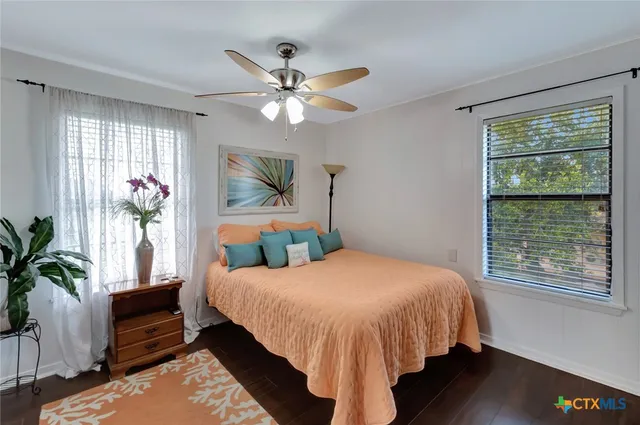 a bedroom with a bed chandelier and a window