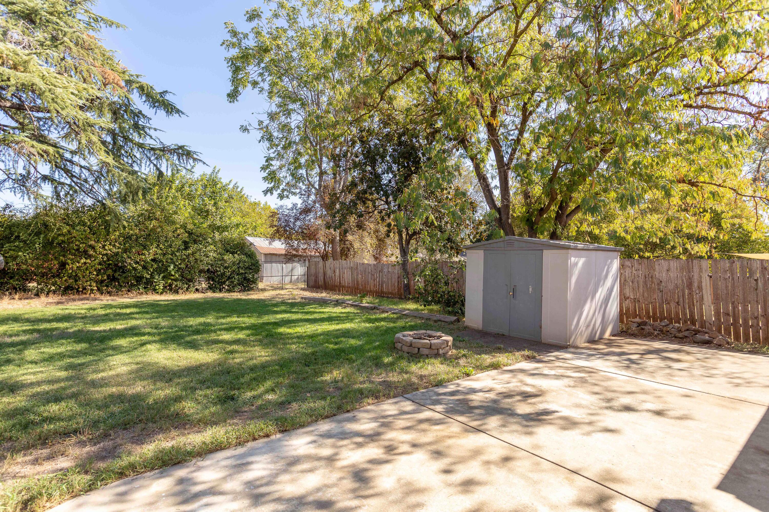 2943 Kenco Avenue Redding, CA 96002 - Photo 15 of 19 a view of a backyard with large tree and wooden fence