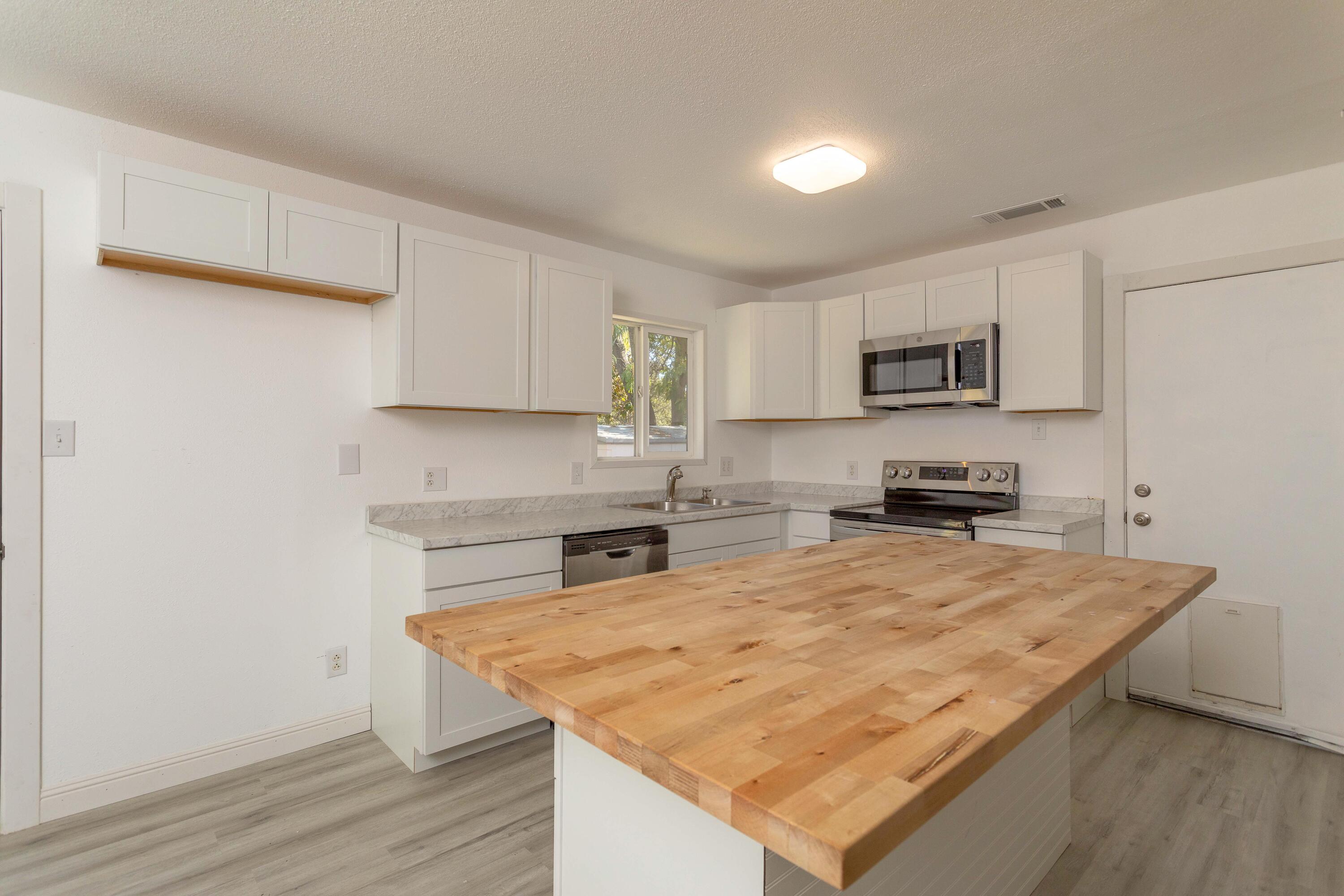 2943 Kenco Avenue Redding, CA 96002 - Photo 3 of 19 a kitchen with sink a microwave and cabinets