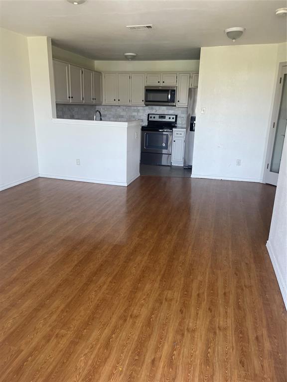 6108 Abrams Road, Unit 613 Dallas, TX 75231 - Photo 27 of 27 a kitchen with a wooden floor and electronic appliances