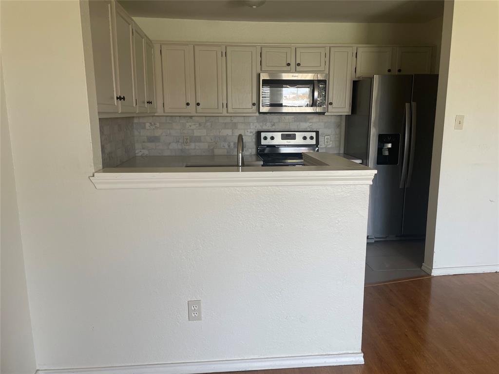 6108 Abrams Road, Unit 613 Dallas, TX 75231 - Photo 19 of 27 a kitchen with stainless steel appliances a refrigerator a stove a microwave and cabinets