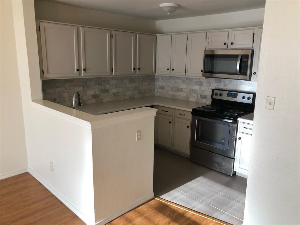 6108 Abrams Road, Unit 613 Dallas, TX 75231 - Photo 3 of 27 a kitchen with granite countertop a stove and a microwave