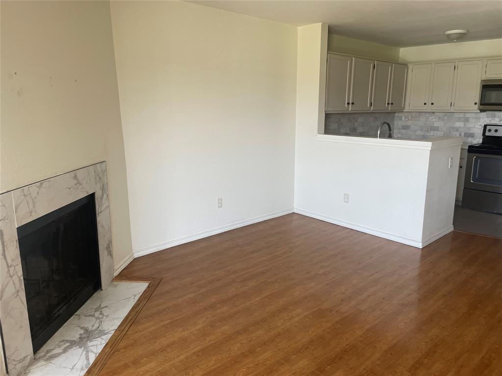 6108 Abrams Road, Unit 613 Dallas, TX 75231 - Photo 5 of 27 a view of kitchen and empty room with wooden floor