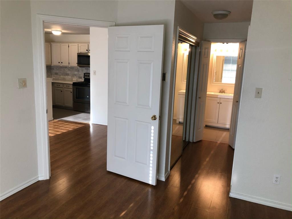 6108 Abrams Road, Unit 613 Dallas, TX 75231 - Photo 8 of 27 a view of a hallway with wooden floor and a bathroom