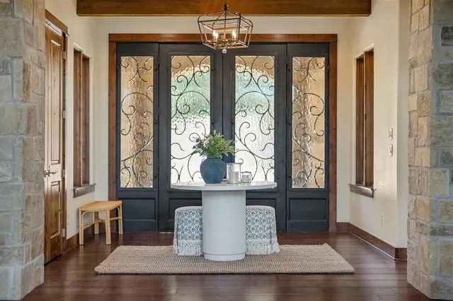 a living room with lots of furniture wooden floor and large windows