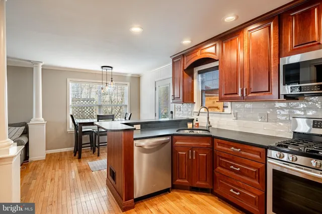 a kitchen with stainless steel appliances granite countertop a stove a sink and a microwave