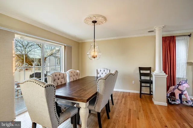 a dining room with furniture a chandelier and wooden floor