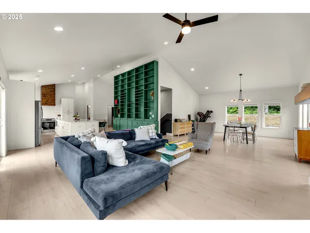 a living room with furniture kitchen view and a large window