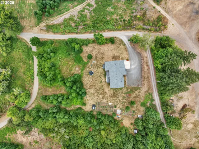 an aerial view of a house with a yard lake and outdoor seating