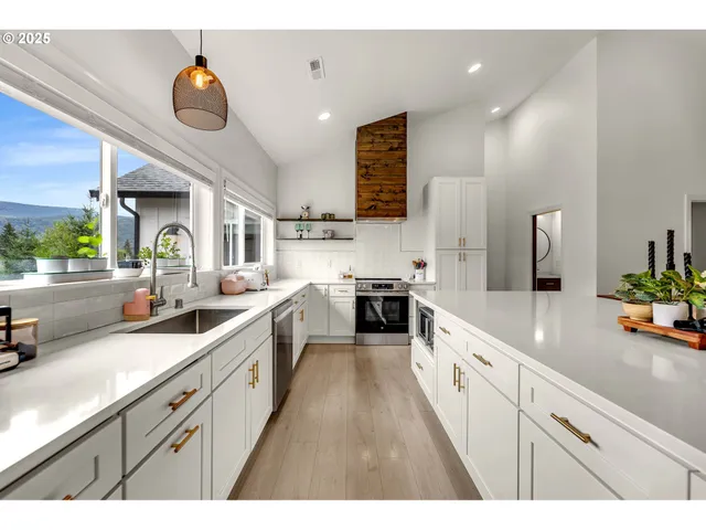 a large kitchen with stainless steel appliances kitchen island granite countertop a sink and cabinets
