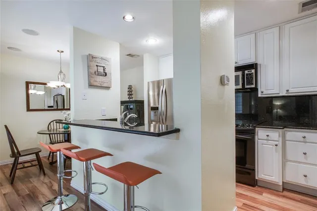 a kitchen with stainless steel appliances kitchen island granite countertop a refrigerator and microwave