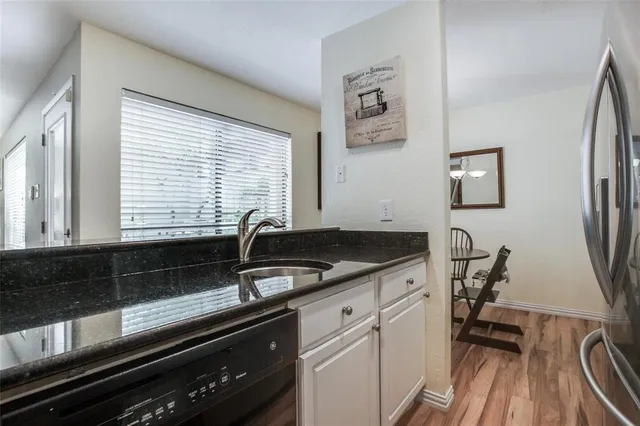 a kitchen with granite countertop a sink and a stove top oven