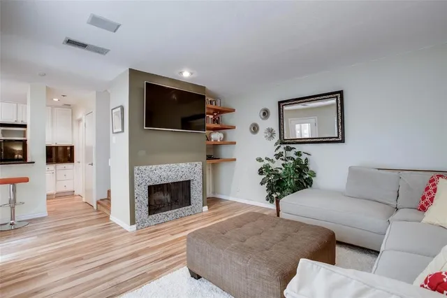 a living room with furniture a potted plant and a fireplace