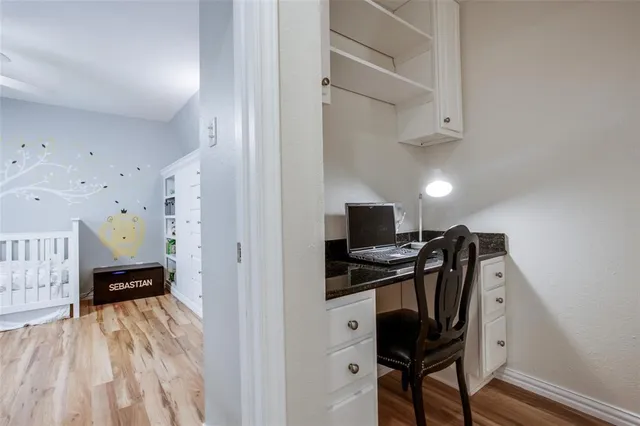 a view of a workspace with furniture and wooden floor